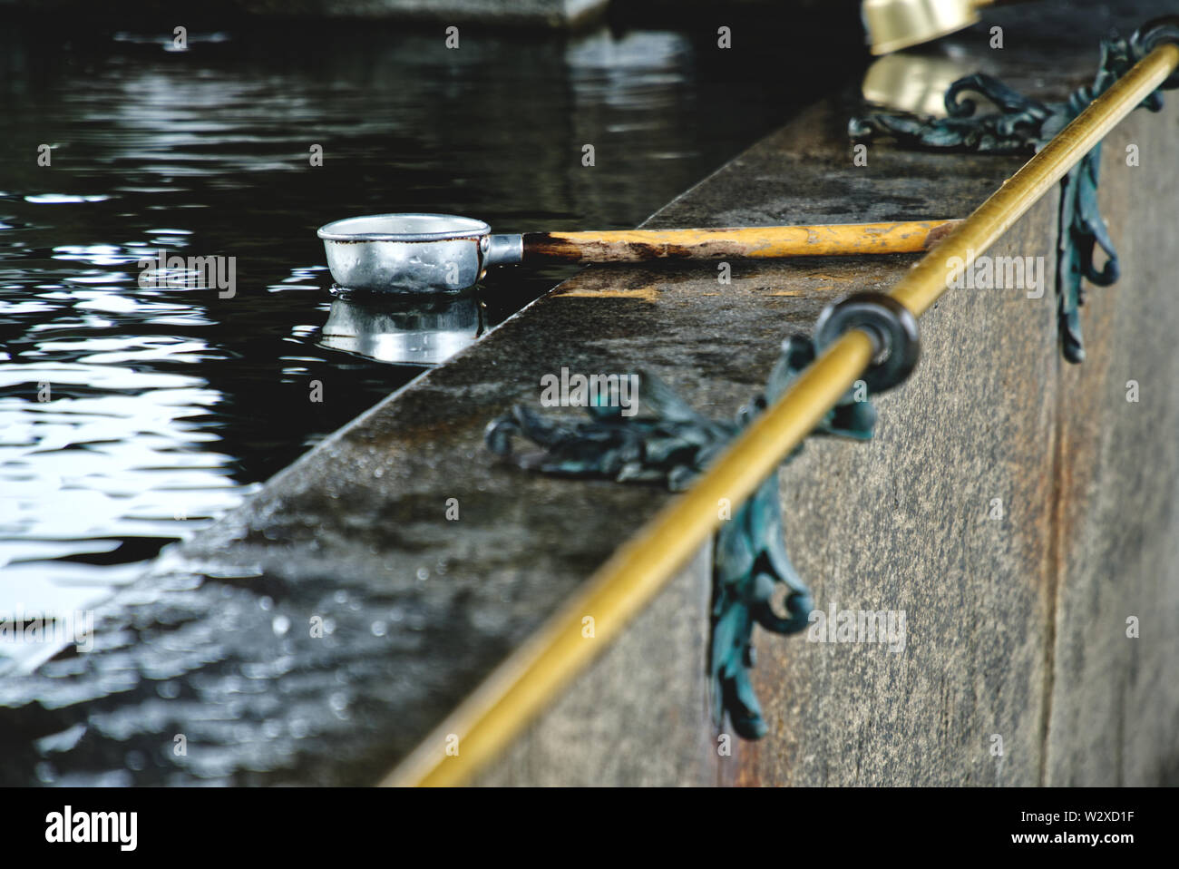 picture showing a water ladle in a ritual well for cleaning at a ...