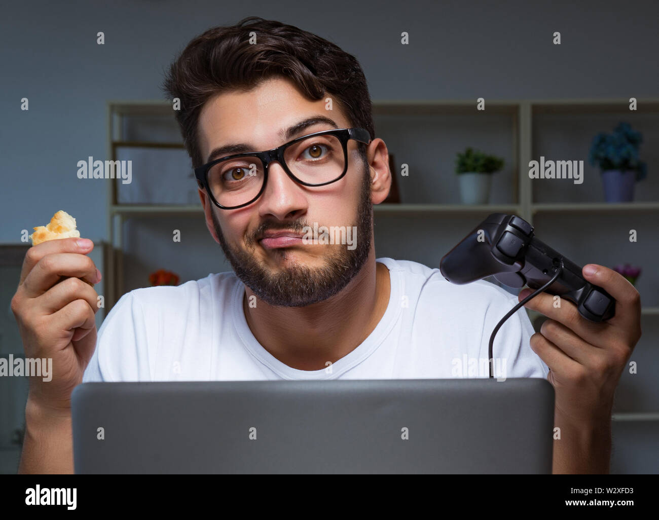 The young man playing games long hours late in the office Stock Photo