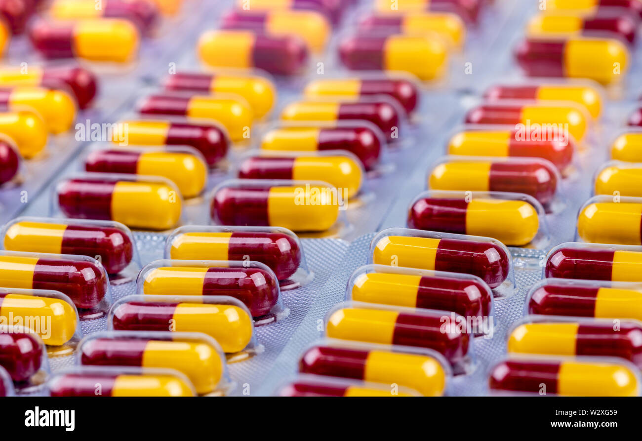 Red-yellow capsule in blister pack. Antibiotic capsule pills. Antimicrobial drug resistance. Penicillin drug for treatment infection. Amoxicillin Stock Photo