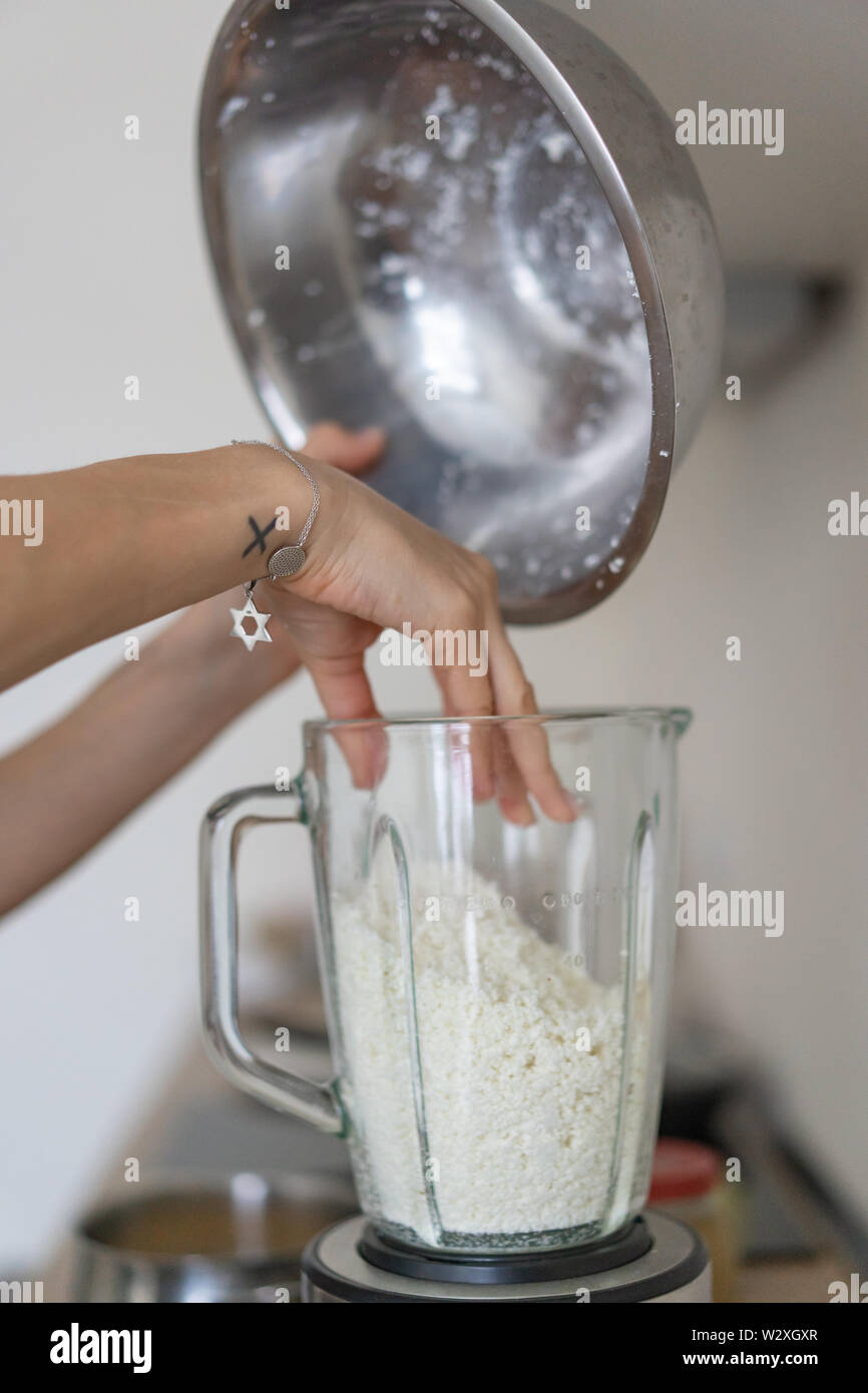 Woman Pouring Cottage Cheese Into A Blender In The Kitchen Stock