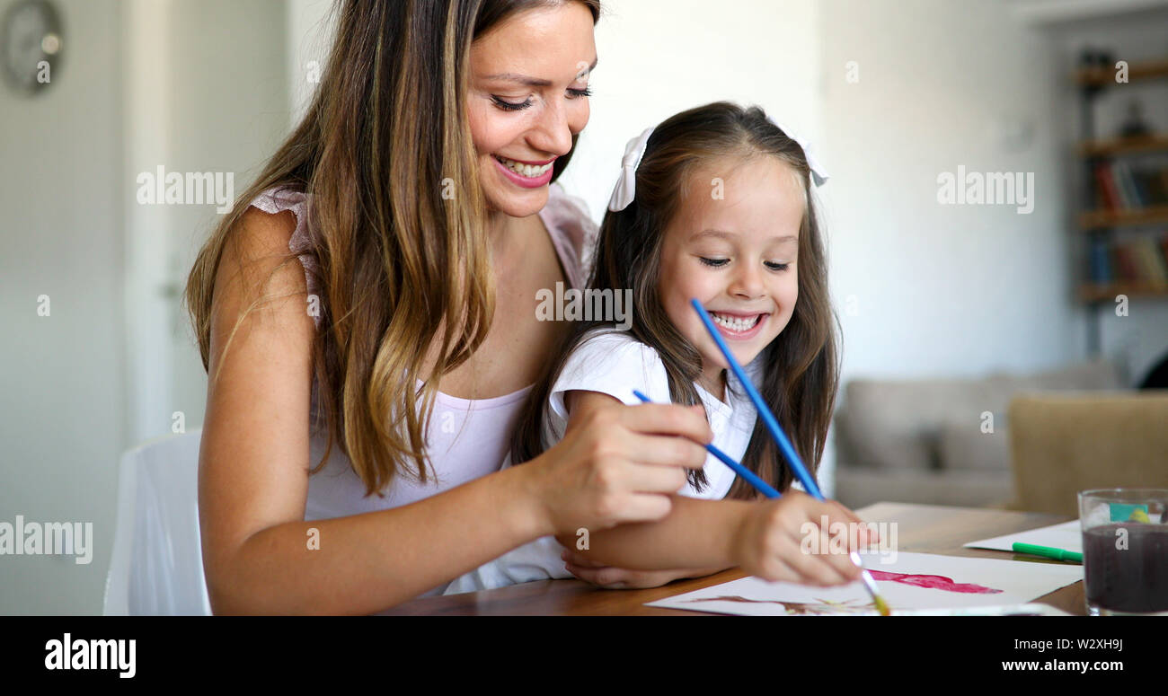 Little girl painting with her mother at home Stock Photo - Alamy