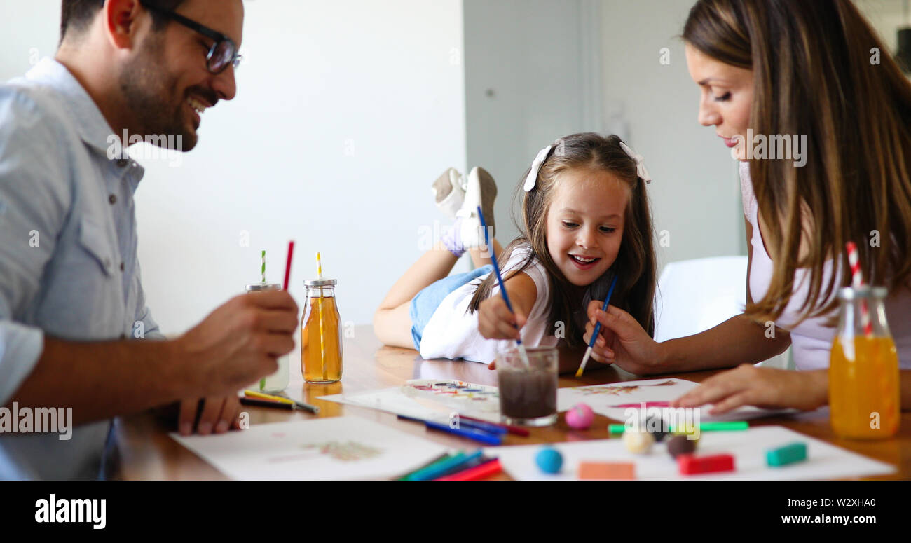 Mom and dad drawing with their daughter Stock Photo - Alamy