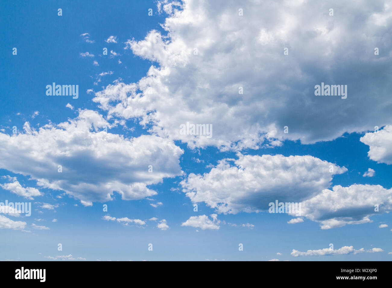 White fluffy clouds in the blue sky in summer Stock Photo - Alamy