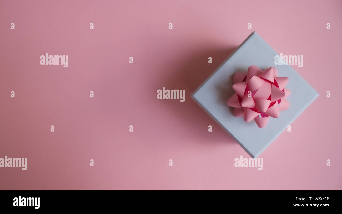 Gift box with pink bow on soft pastel color background. Flat lay ...
