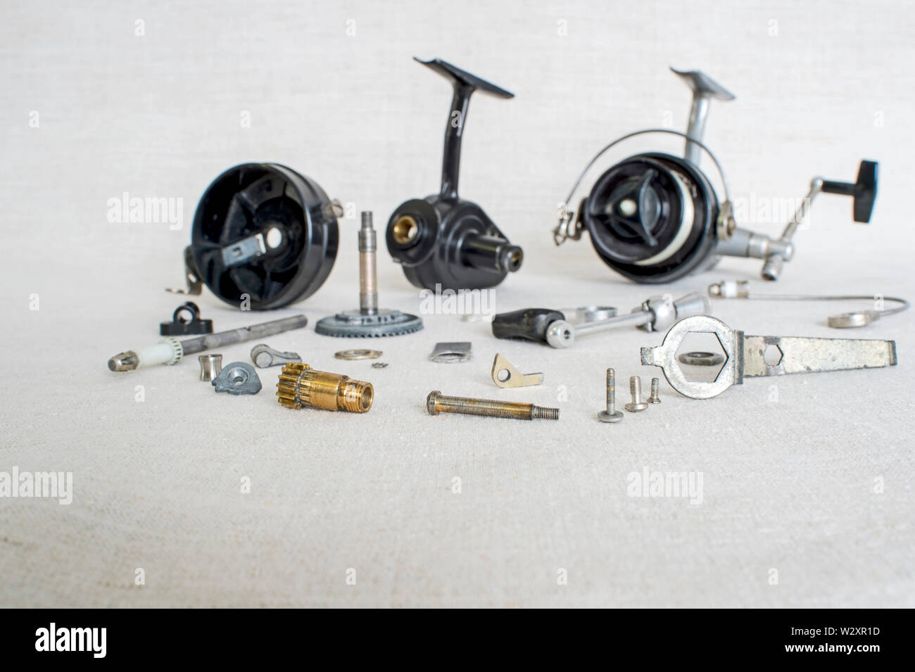 https://c8.alamy.com/comp/W2XR1D/a-fishing-spinning-reel-as-a-whole-and-a-second-similar-completely-disassembled-concept-parts-of-a-whole-W2XR1D.jpg