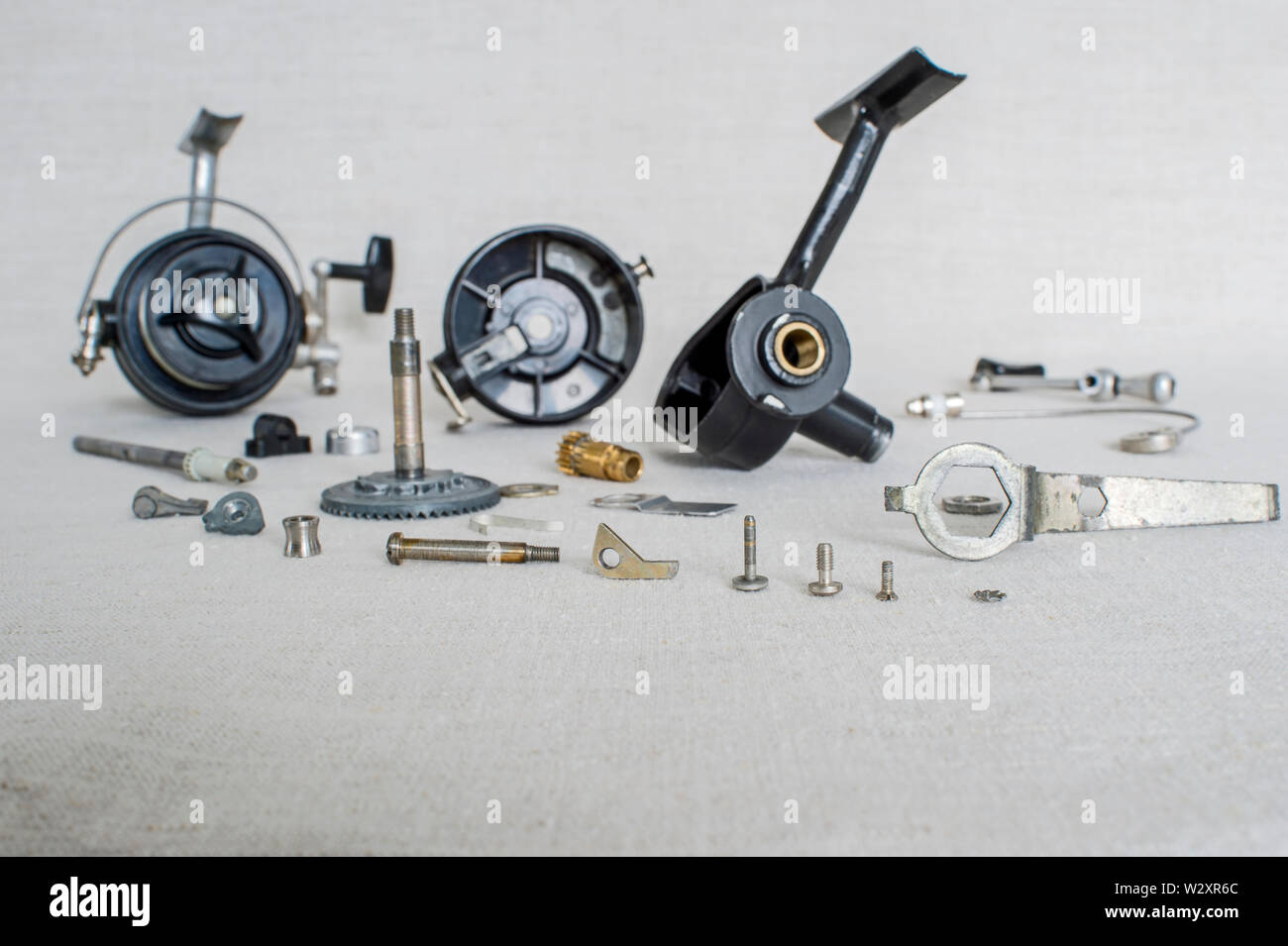 A fishing spinning reel as a whole and a second similar completely  disassembled. Concept: parts of a whole Stock Photo - Alamy