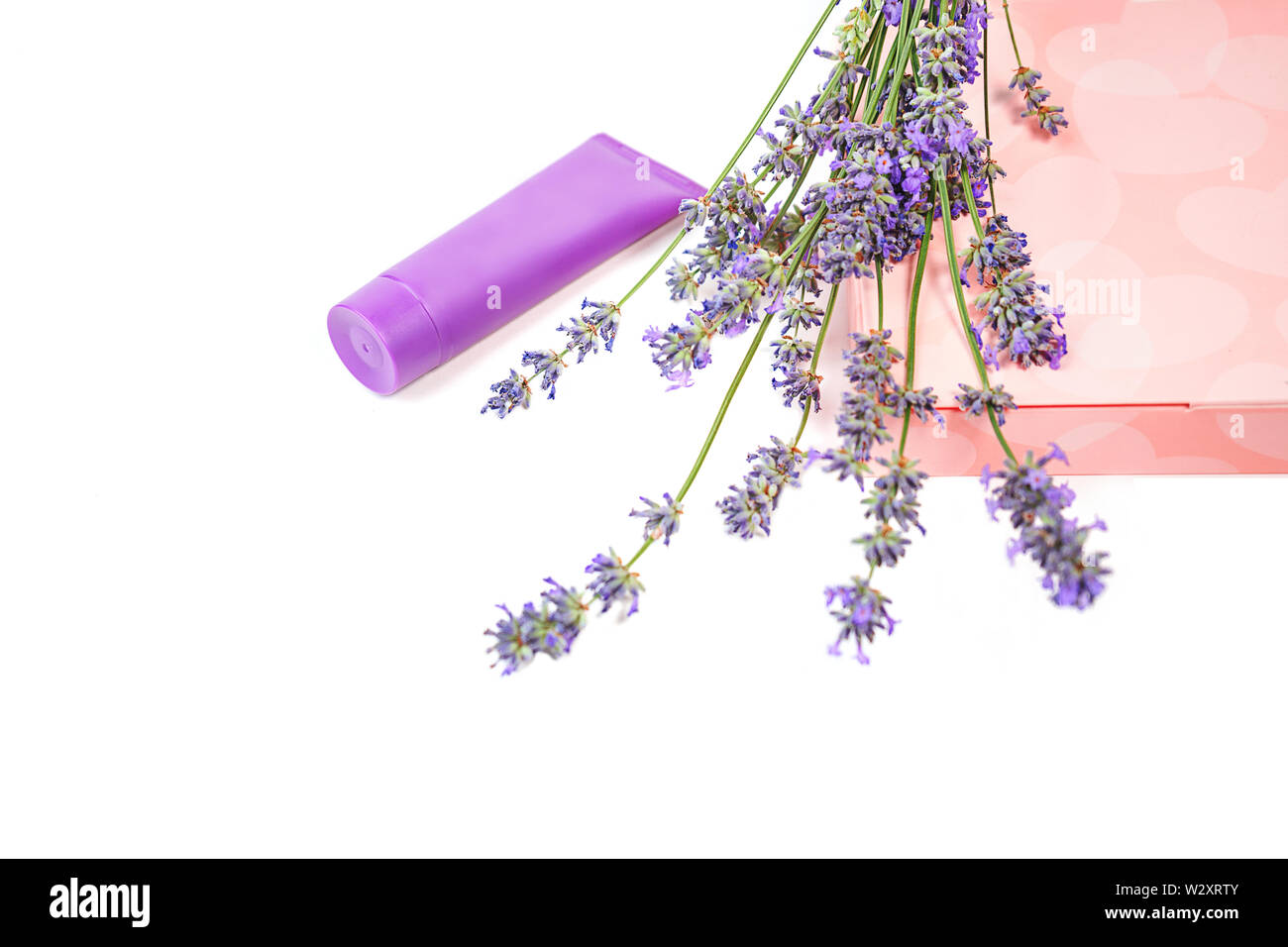 Cosmetic cream and lavender flowers, gift box with sweets on white