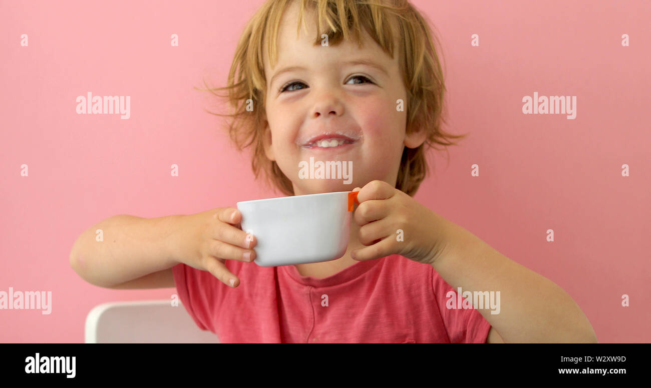 Happy child drinks milk from a cup Stock Photo Alamy
