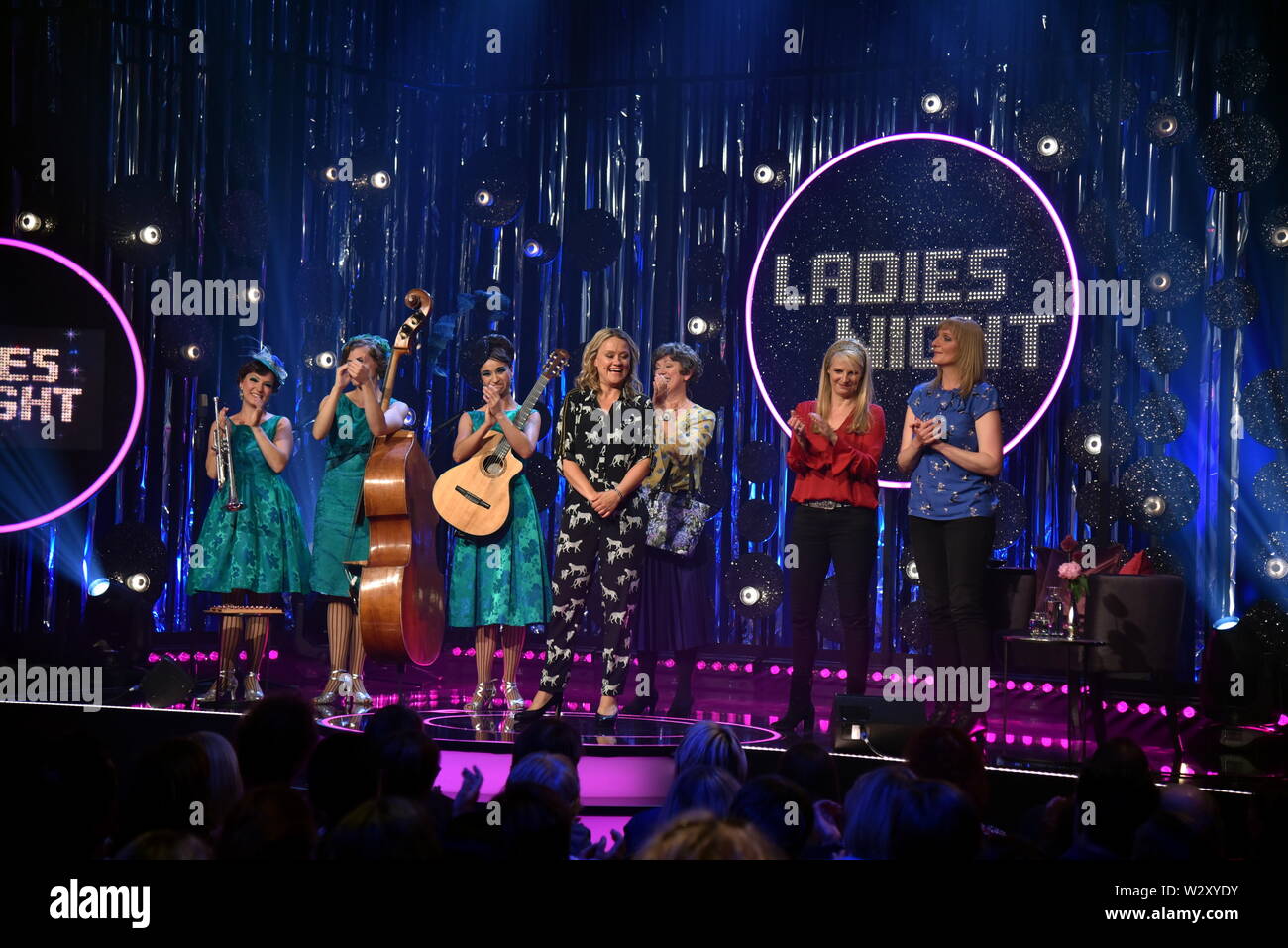 10 July 2019, North Rhine-Westphalia, Cologne: Trio Zucchini Sistaz ( Sinje Schnittker, Jule Balandat and Tina Werzinger ) , l-r, Lioba Albus, hostess Lisa Feller, Barbara Ruscher and Katinka Buddenkotte  guest on the recording of Ladies Night, a ARD cabaret television programme in which only women appear - broadcast date 08.08.2019, 22.45 in the first Photo: Horst Galuschka/dpa/Horst Galuschka dpa Stock Photo