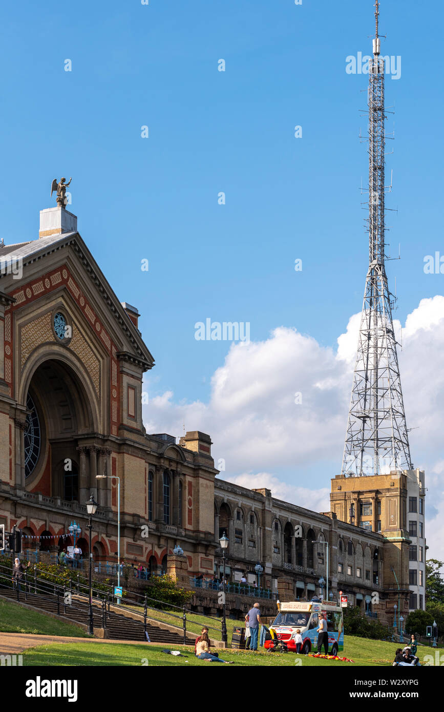 Alexandra Palace entrance and BBC Television studios and aerial mast. Sunny summer day with ice cream van and people. Grade II listed building Stock Photo
