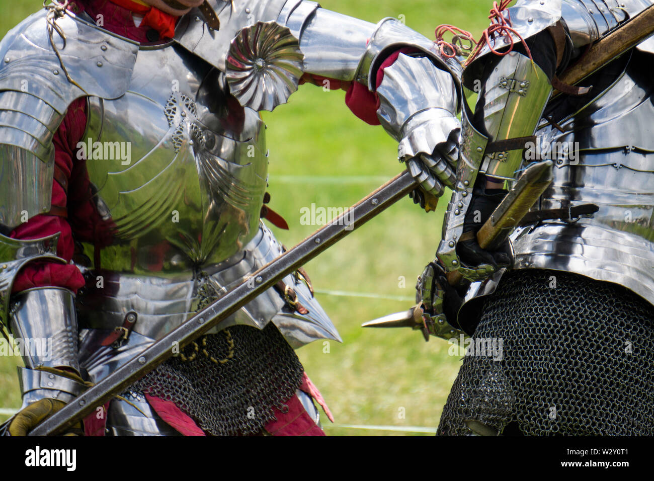Two medieval knights in armour battle with weapons Stock Photo Alamy