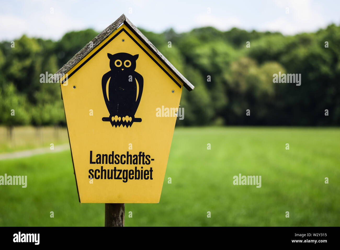 German sign for a nature reserve - Landschaftsschutzgebiet Hinweistafel gelb mit Uhu Stock Photo