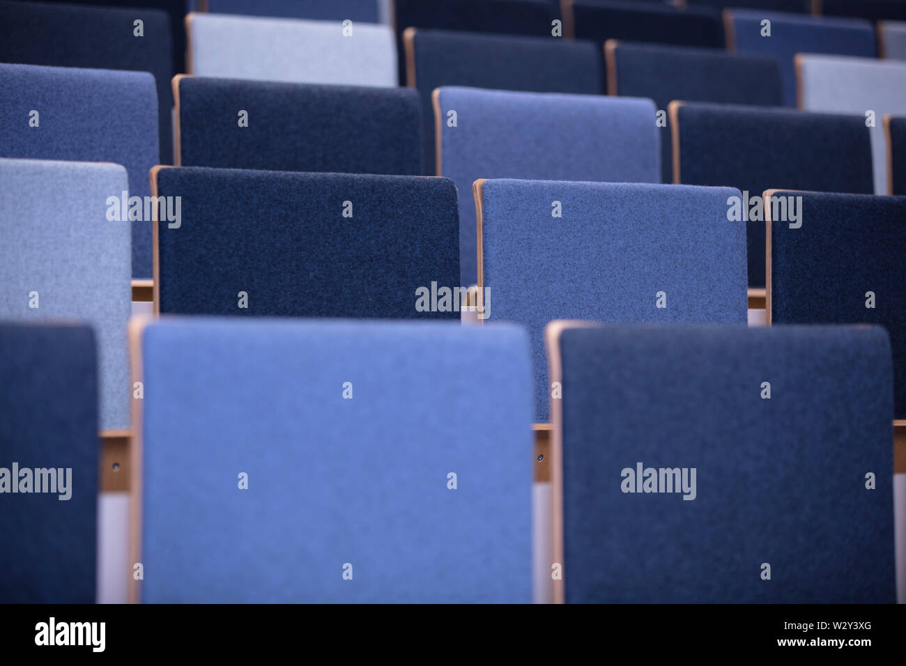 Rows of empty blue chairs in a conference room Stock Photo