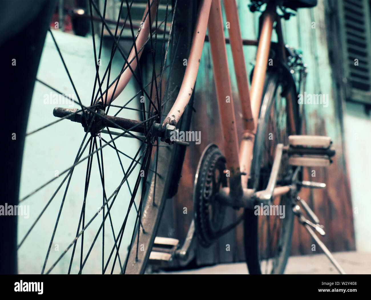 Amazing close up old bicycle front of antique house, wheel of bike rust