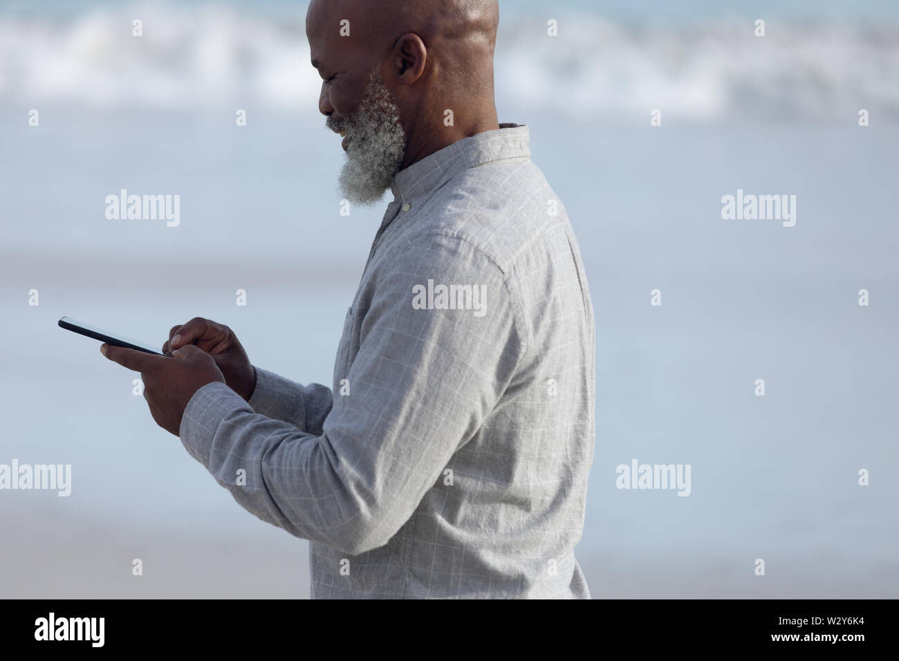 Man using a mobile phone at the beach Stock Photo