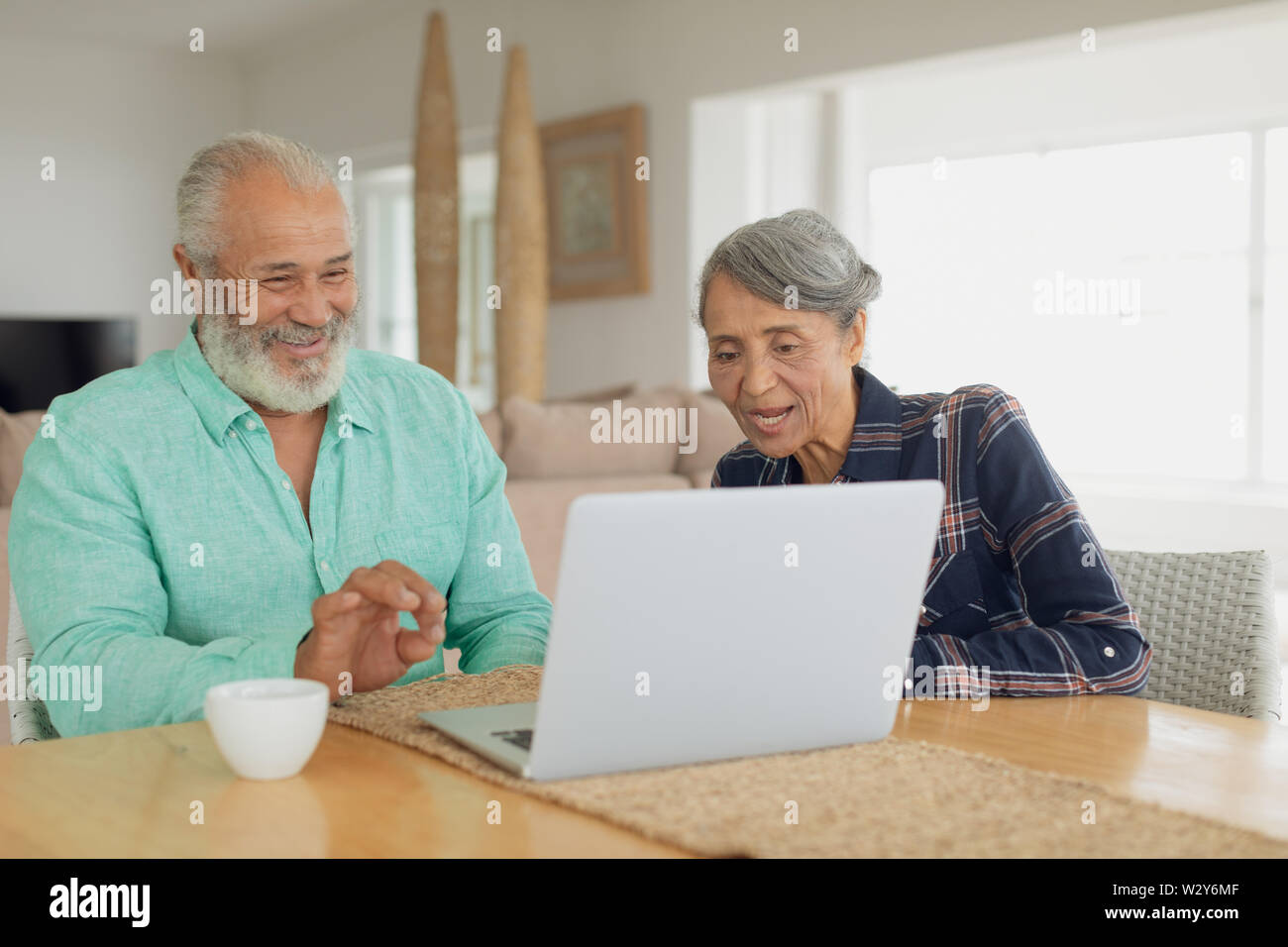 Couple using laptop on table inside a room Stock Photo