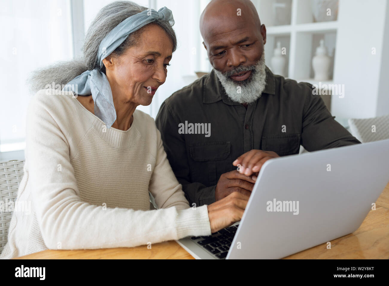 Couple using white laptop on a table. Stock Photo