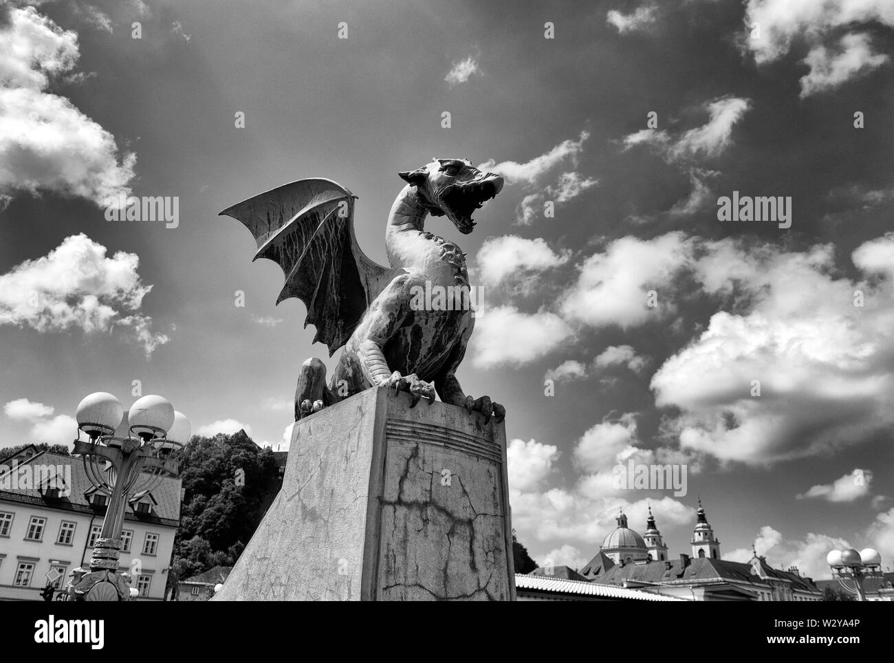The Dragon statues at the Dragon Bridge and Cathedral of St. Nicholas at the background in center of Ljubljana, Slovenia Stock Photo