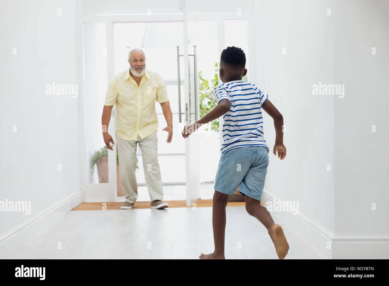 Boy running towards grandfather Stock Photo