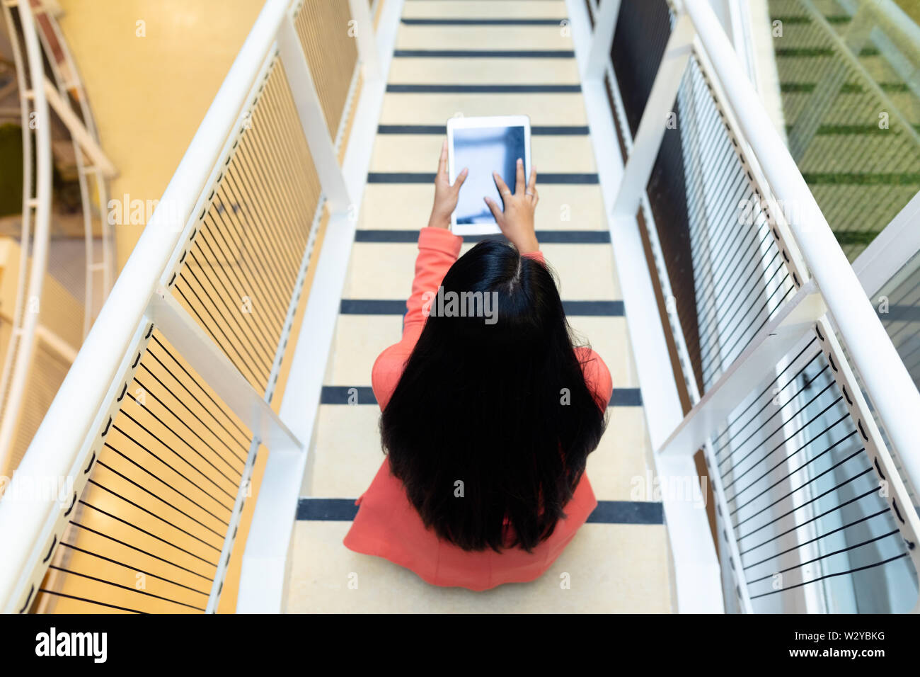 Businesswoman using digital tablet on stairs Stock Photo