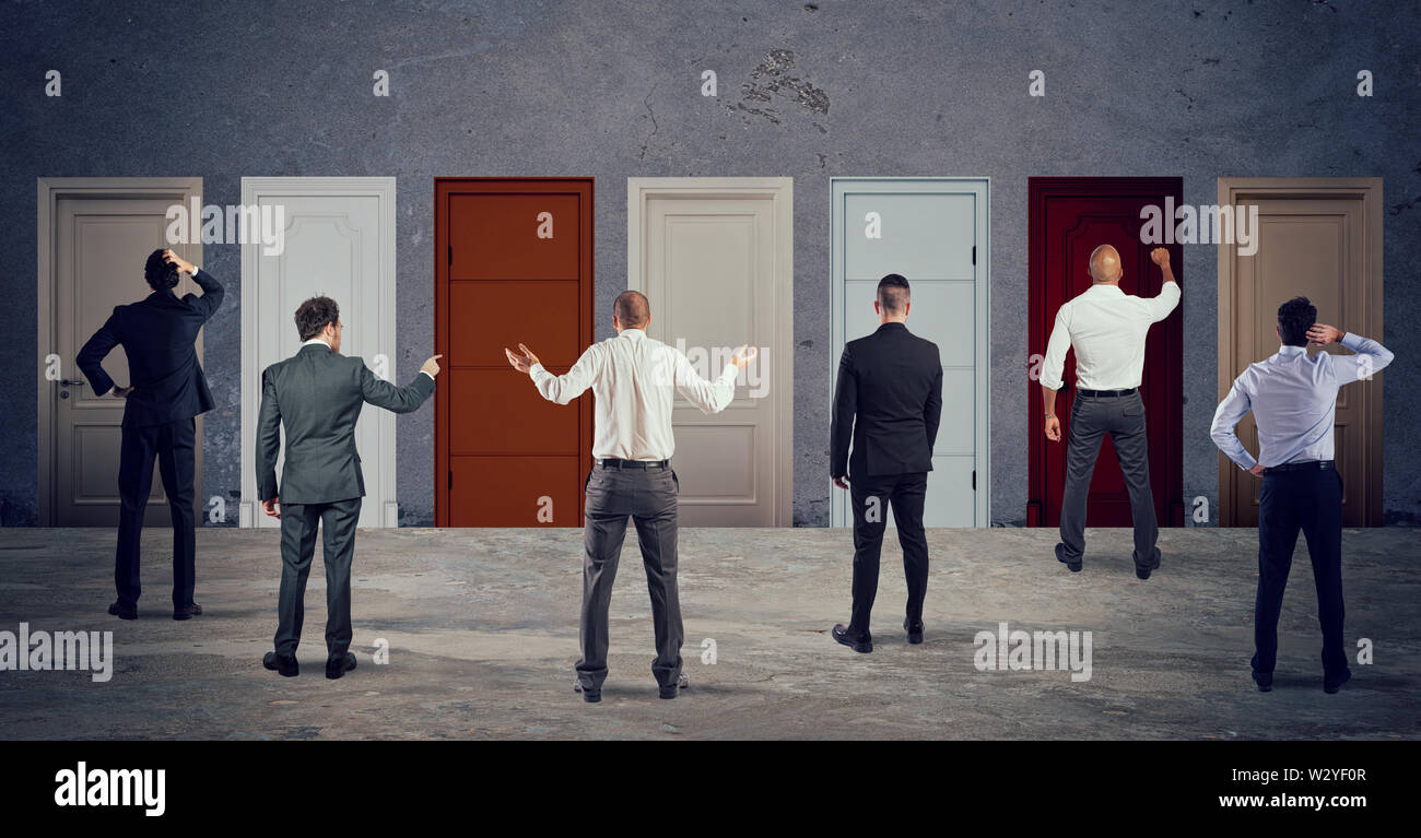 Business people looking to select the right door. Concept of confusion and competition Stock Photo