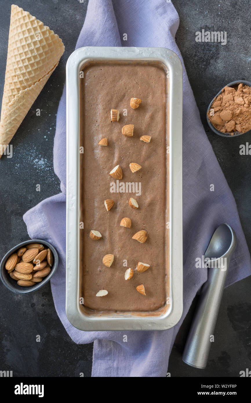 Banana and chocolate homemade ice cream in container on black. Top view