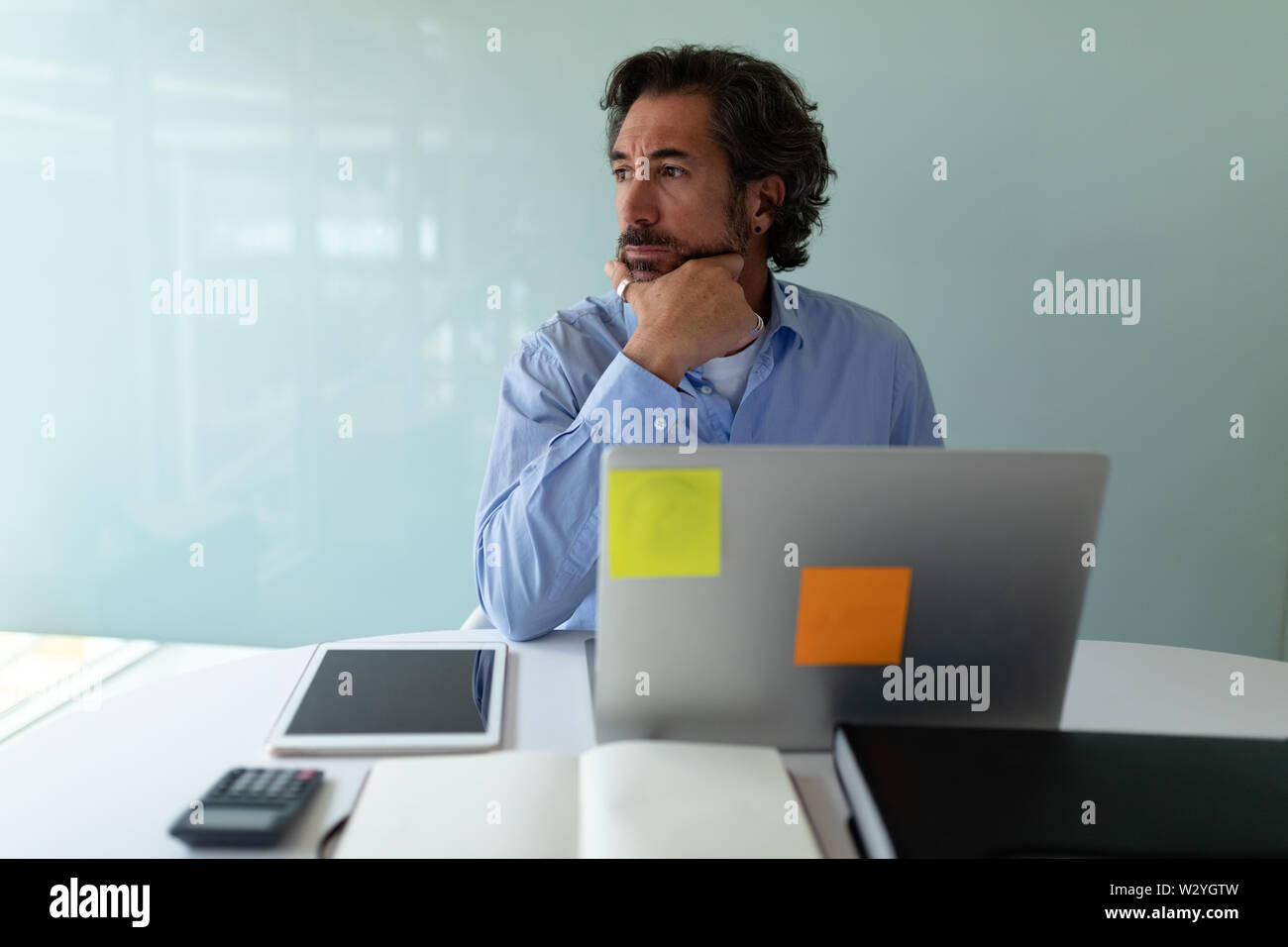 Businessman looking away while working at desk in office Stock Photo
