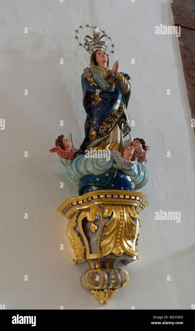 A Religious and ornately carved and painted wall Statue on the inside walls of the Paroquia de S Martinho, in the main square of Estoi, Portugal. Stock Photo