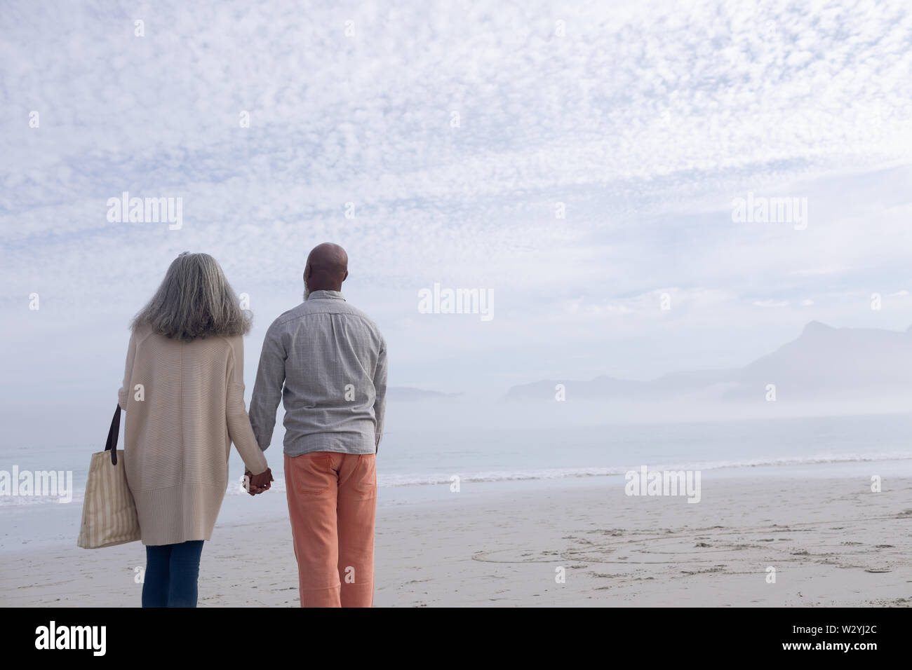 Couple holding hands by the beach Stock Photo - Alamy