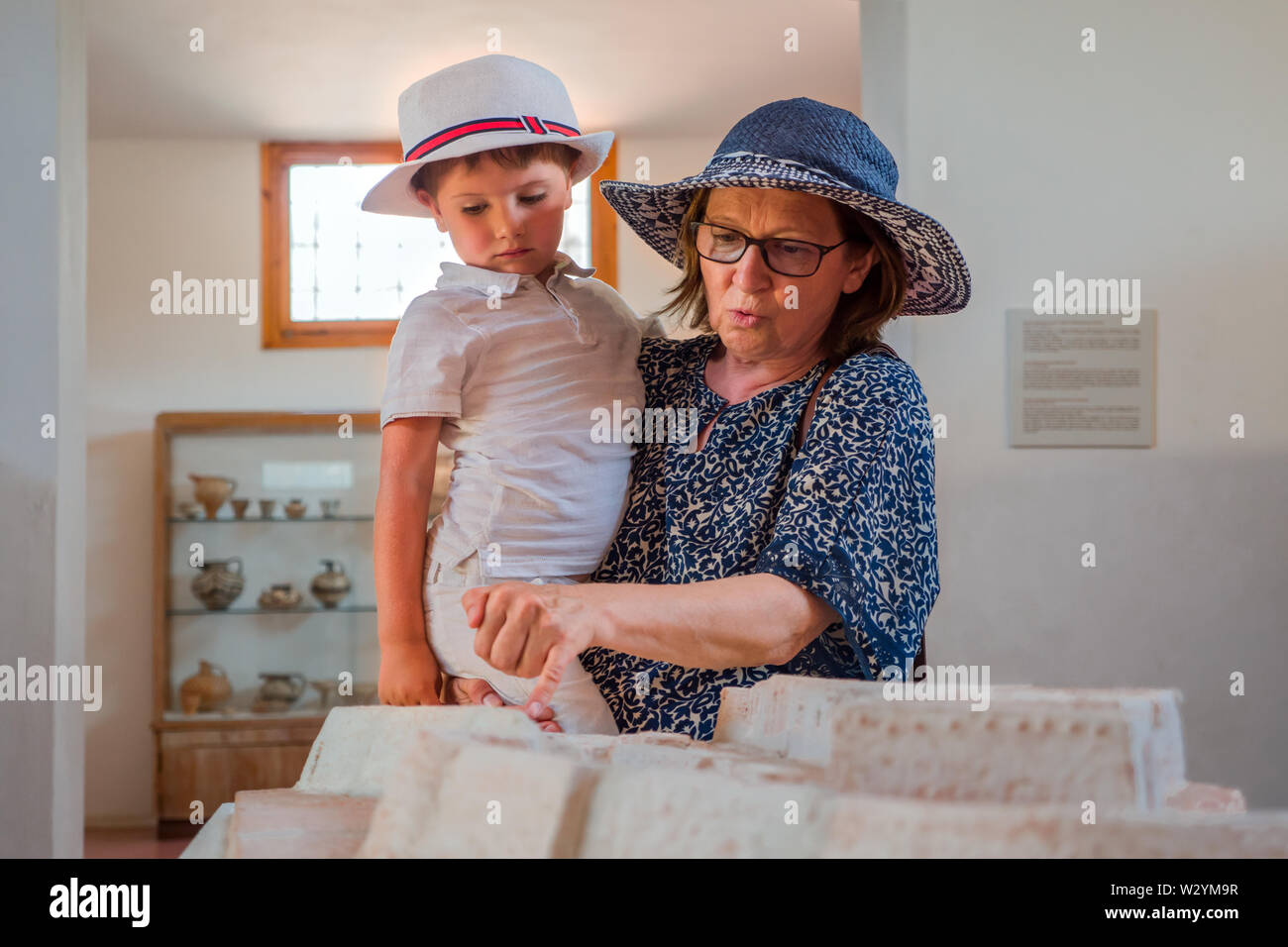 Grandmother holding grandson in his arms. Traveling concept. Tourism background. Summer vacation. Mother with son. Family background. Relations and Stock Photo