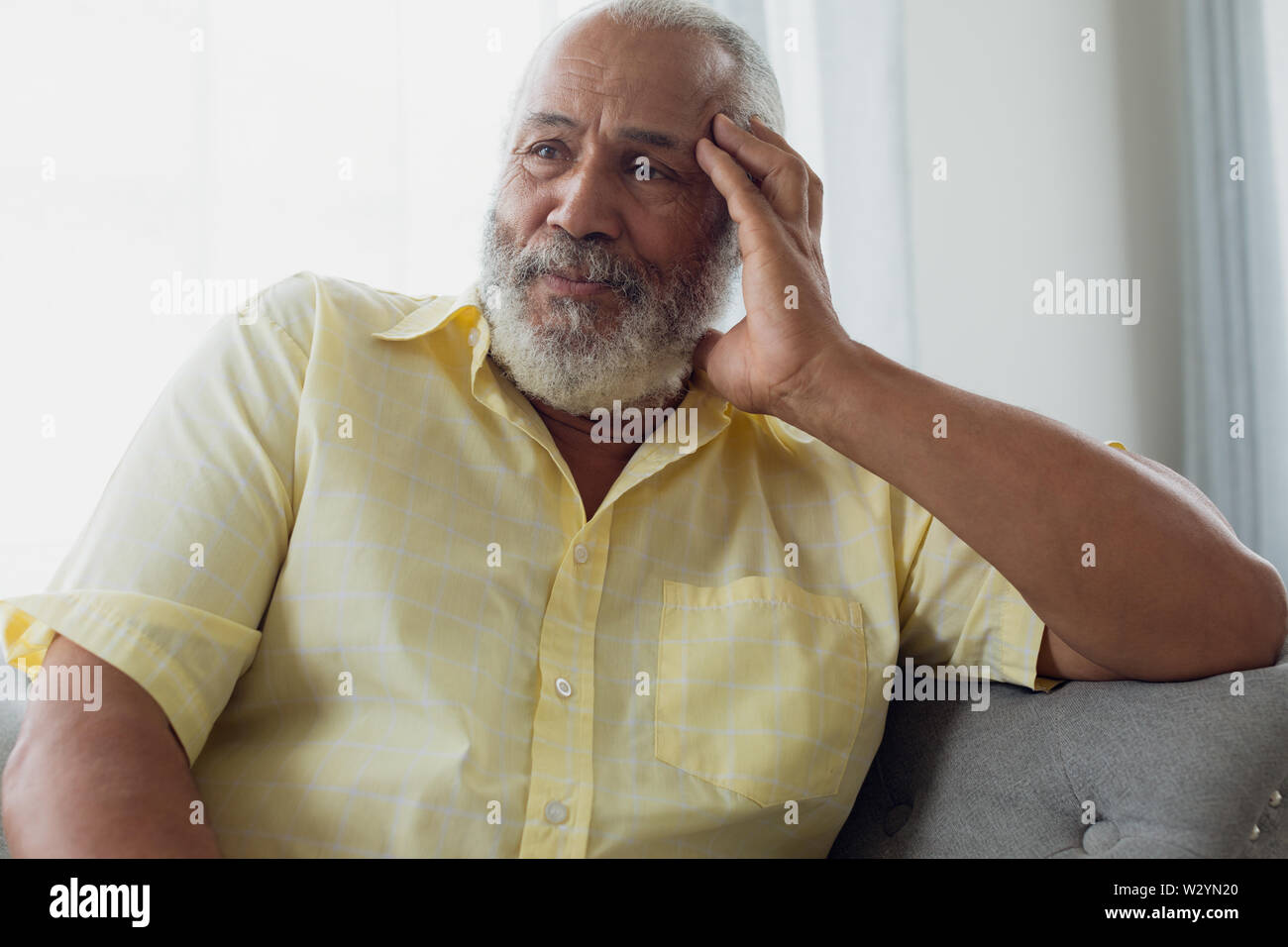 Man sitting on couch Stock Photo