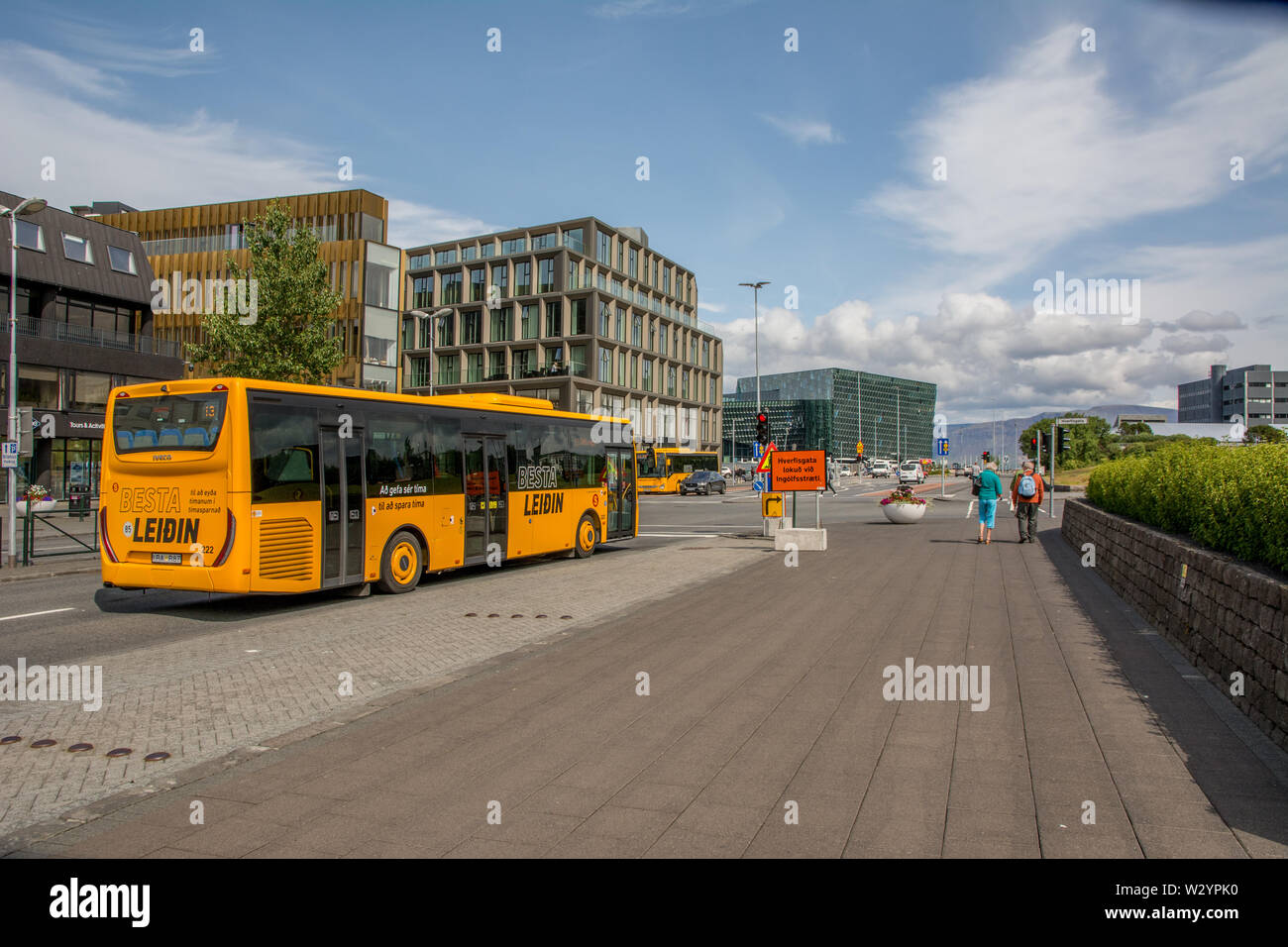 Iceland, Reykjavik, July 2019: view on the Laekjargata, Harpa museum in background, yellow Besta Leidin public transport bus in foreground Stock Photo