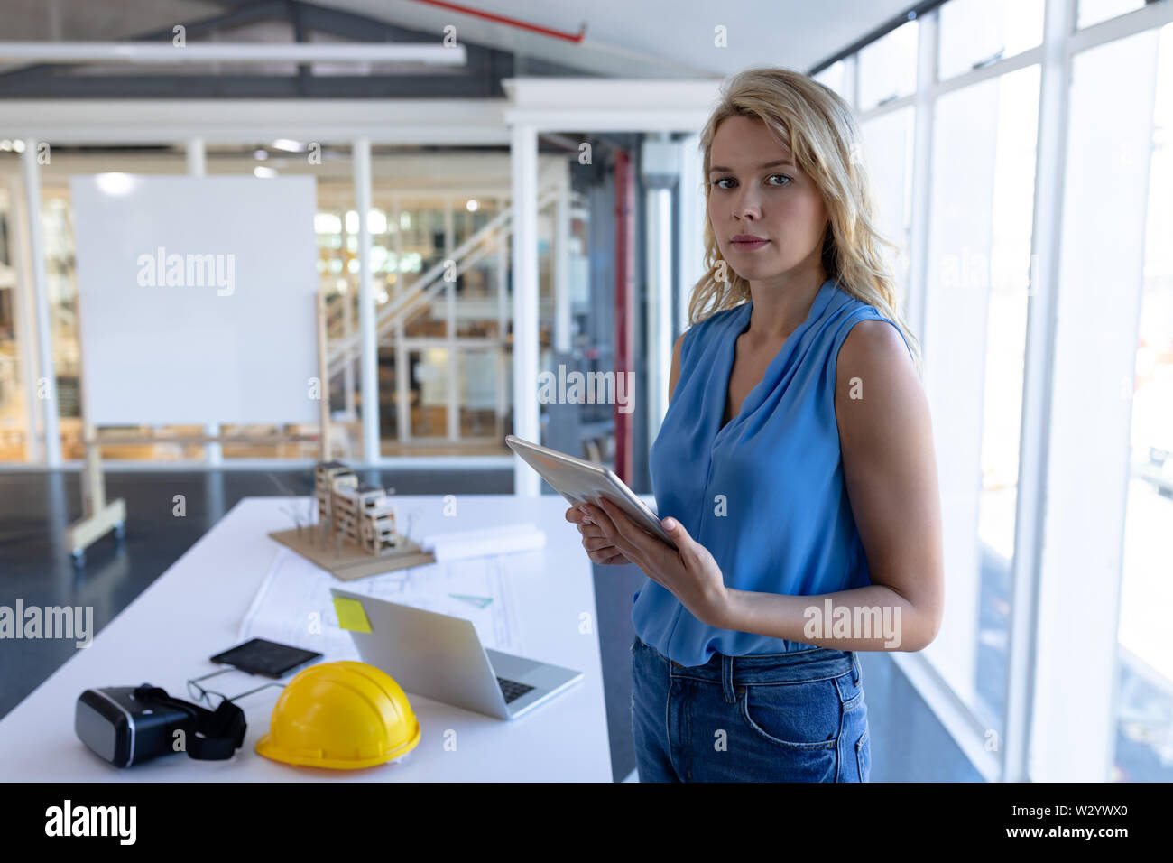 Female architect with digital tablet looking at camera in a modern ...
