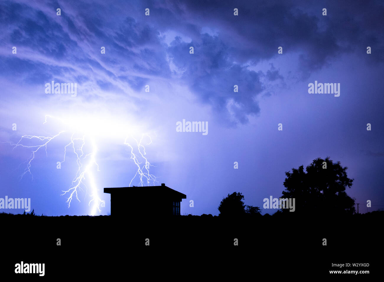 Lightning flashes over the night sky during thunderstorm Stock Photo