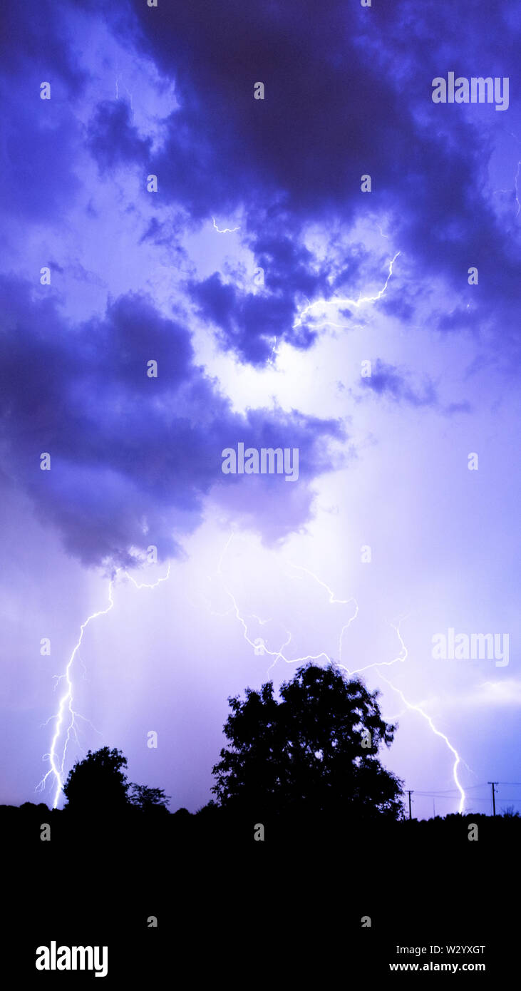 Lightning flashes over the night sky during thunderstorm Stock Photo