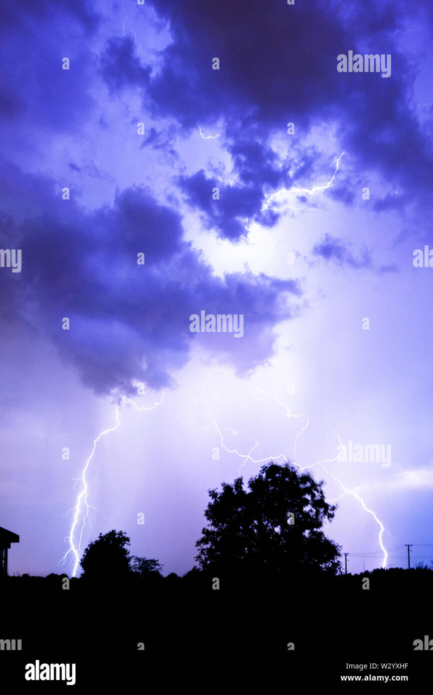 Lightning flashes over the night sky during thunderstorm Stock Photo