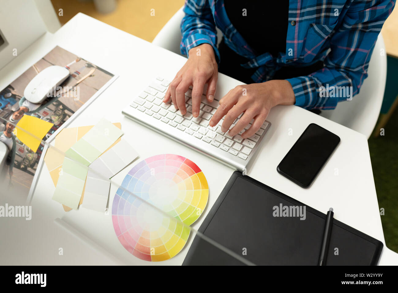 Female graphic designer working on computer at desk Stock Photo