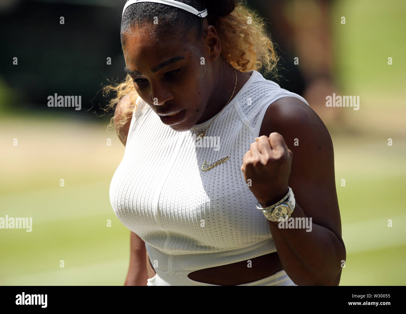 Serena Williams reacts after breaking serve during the women's singles semi final match on day ten of the Wimbledon Championships at the All England Lawn Tennis and Croquet Club, London. Stock Photo