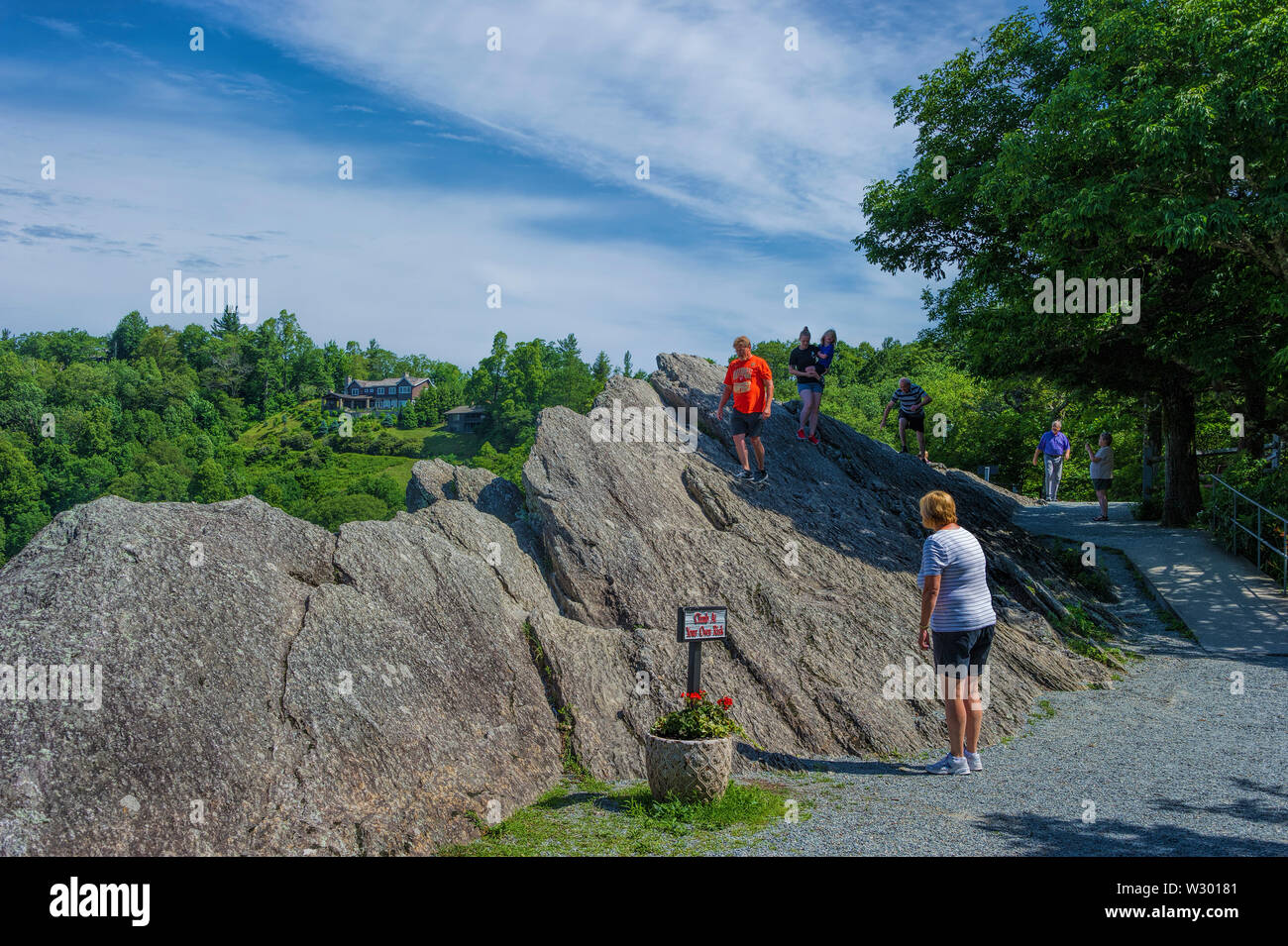 Blowing Rock, North Carolina,USA -  June 12, 2019: Tourist climb on the top of Blowing Rock a natural trourist attraction, well known for the only pla Stock Photo