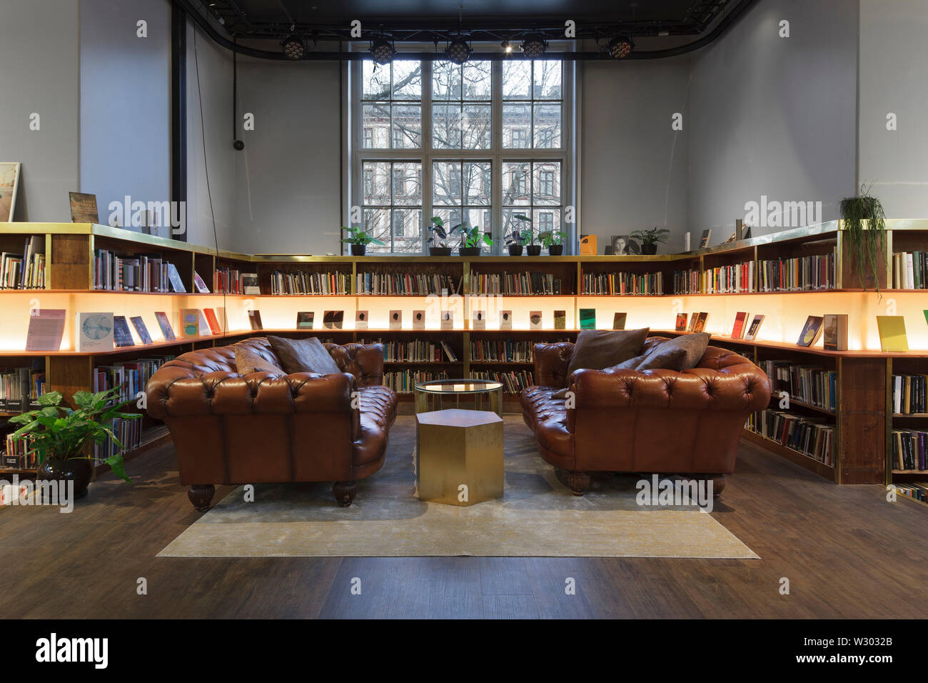 Main reading room on ground floor, with illuminated display shelf and leather sofas. Deichman Library Grunerlokka, Oslo, Norway. Architect: Aat Vos, 2 Stock Photo