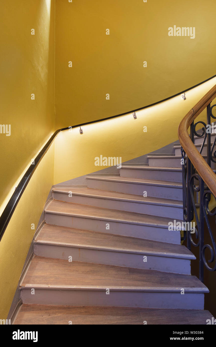 Detail of main staircase with yellow walls. Deichman Library Grunerlokka, Oslo, Norway. Architect: Aat Vos, 2019. Stock Photo