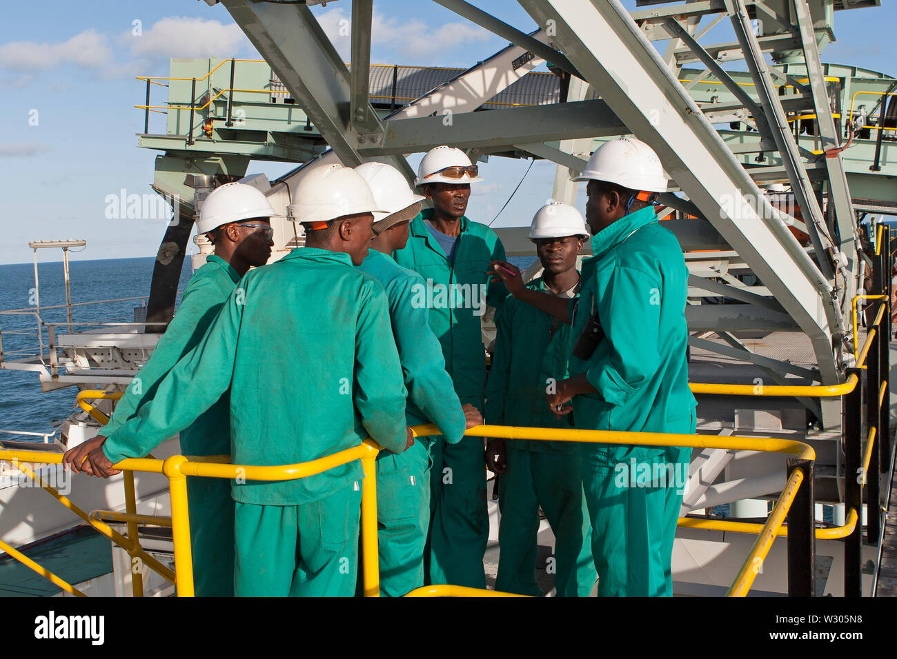 Port Operations for transporting of titanium mineral sands. Briefing on jetty movements of riggers & marine workers during barge loading operations. Stock Photo