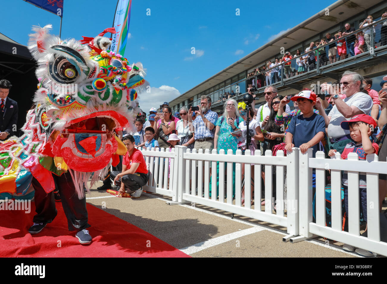 Traditional Chinese lion dance at London Hong Kong Dragon Boat Festival in beautiful sunshine,  Royal Docks in London, UK Stock Photo