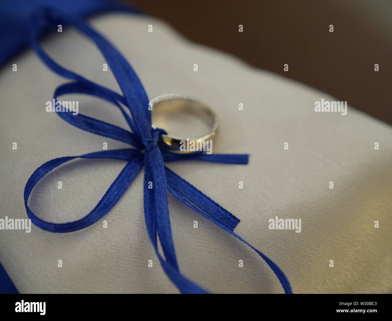 Wedding ring tied with a royal blue ribbon Stock Photo Alamy
