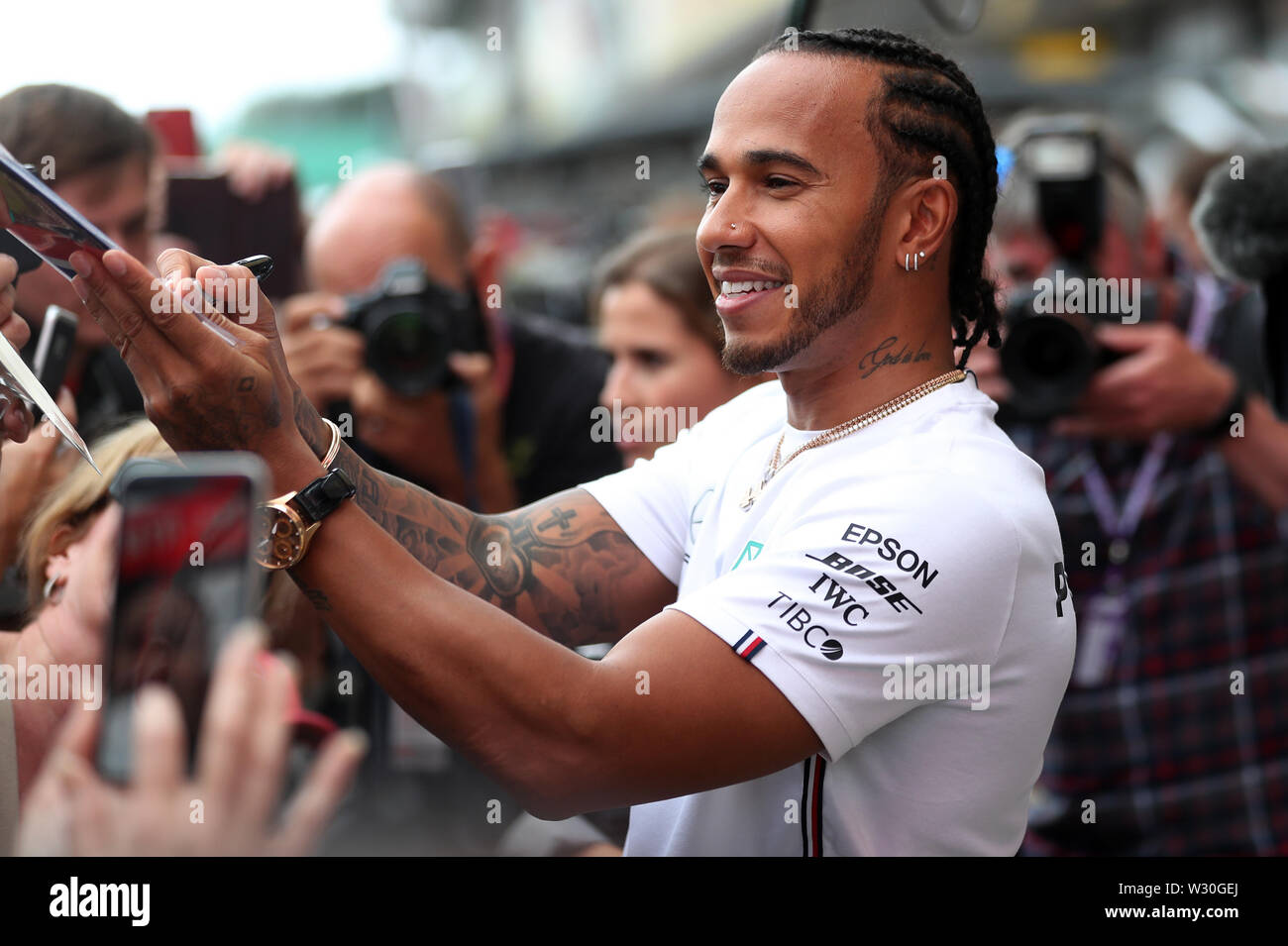 Mercedes' Lewis Hamilton signs autographs during a preview day for the