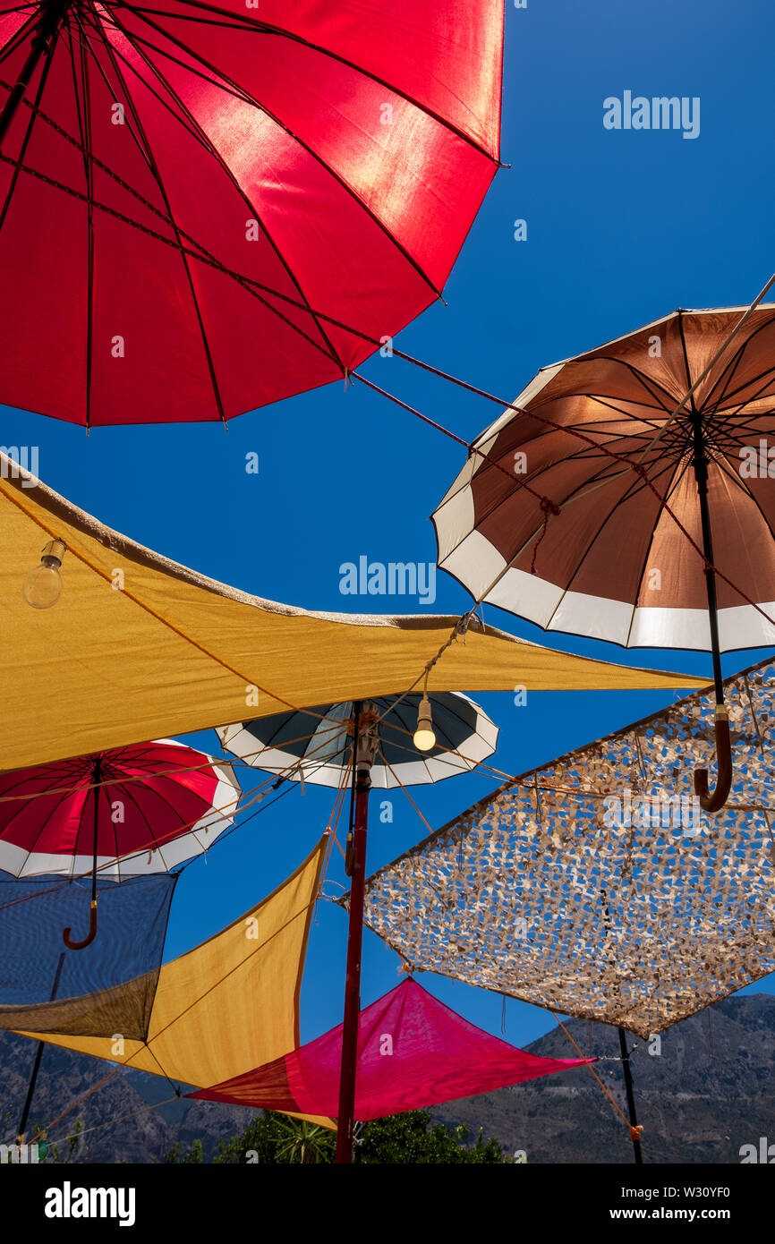 Colourful umbrellas against blue sky covering taverna terrace in village of Vasiliki, Crete, Greece Stock Photo