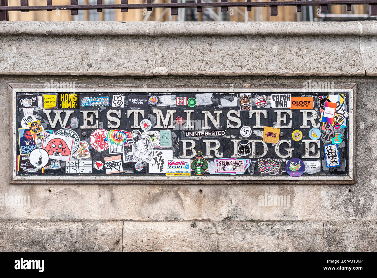 Westminster Bridge road name sign, London, UK, covered in stickers. Zapped. Plastered with political statements and promotional paper stickers Stock Photo