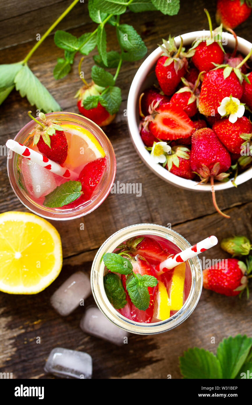Fresh Strawberry lemonade on rustic wooden table. Top view flat lay background. Stock Photo