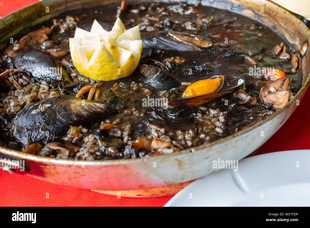 Close-up of black rice with squid –in ink– mussels, clams and other