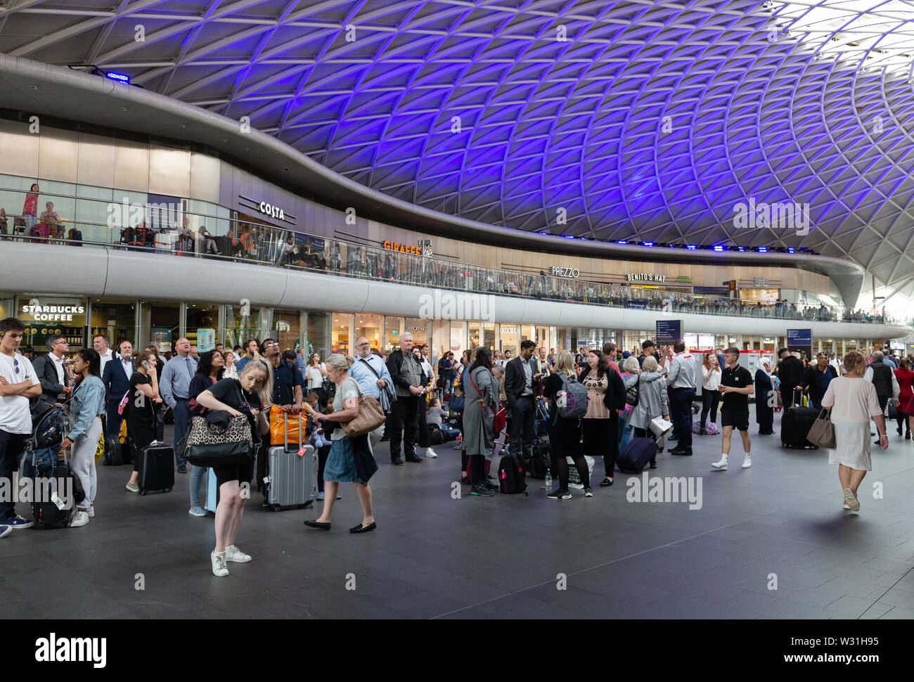 Kings Cross Station concourse with shops and passengers, Kings Cross